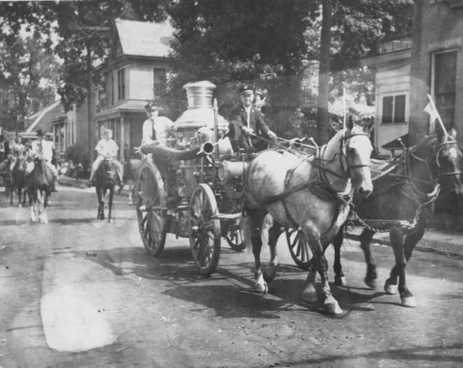 #48 Firemen riding Engine No .2 during a procession, 1960