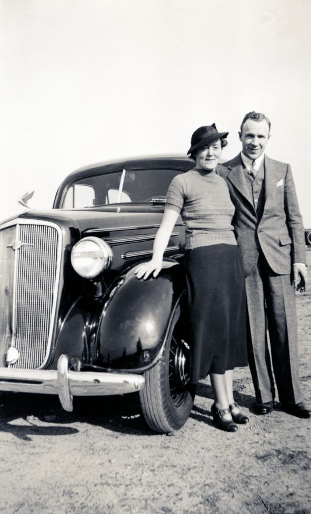 #16 A stylish couple posing with a 1935 Chevrolet Master Deluxe in late afternoon sunshine, circa 1936