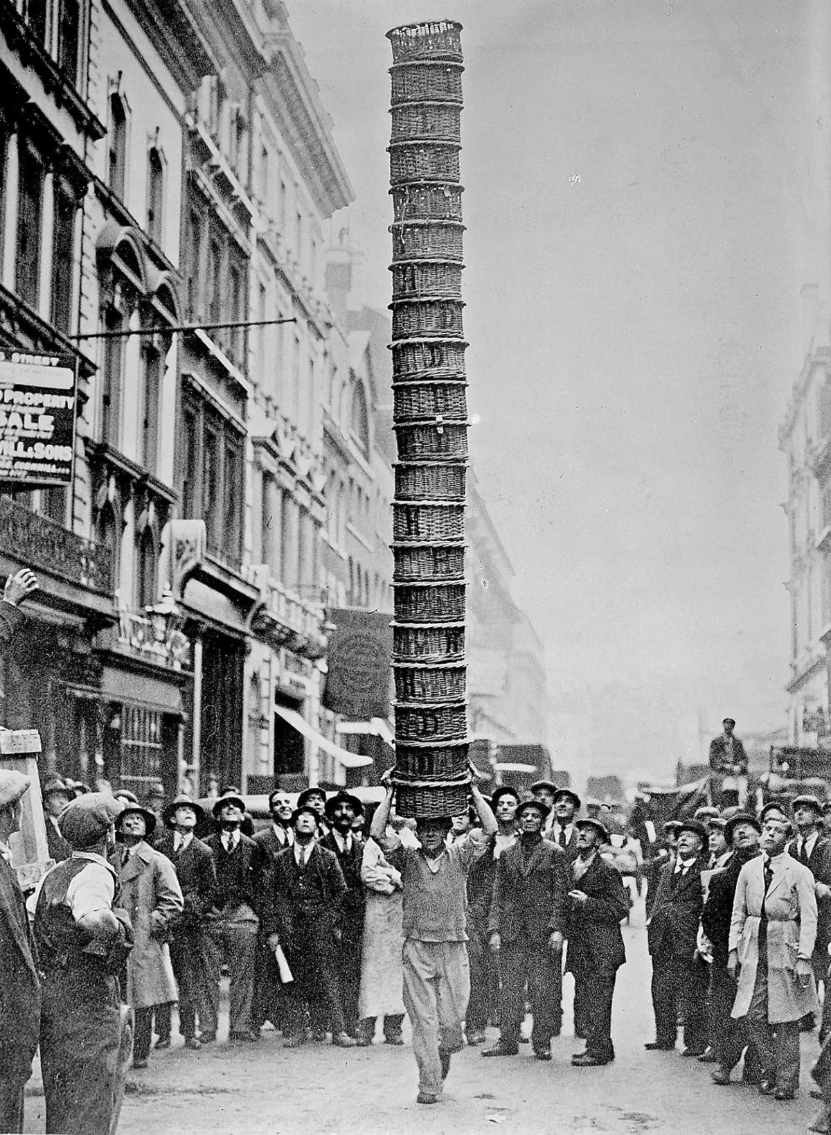 #9 E. W. White, porter, carrying twenty baskets stacked to King Street, Covent Garden, 1931.