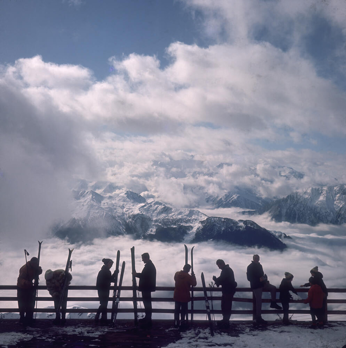 #8 Skiers admire the view across a valley of clouds at Verbier, 1964.