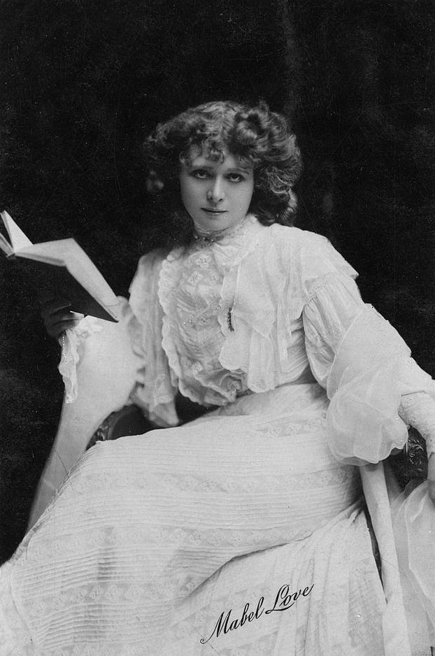 #7 Mabel Love stares intently into the camera for a photo postcard issued early 20th century in London, England.
