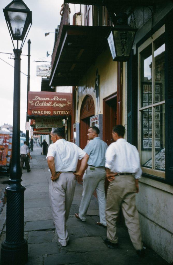 #54 A view as men walk down bourbon street toward the Dream Room Cocktail Bar n New Orleans, 1957.