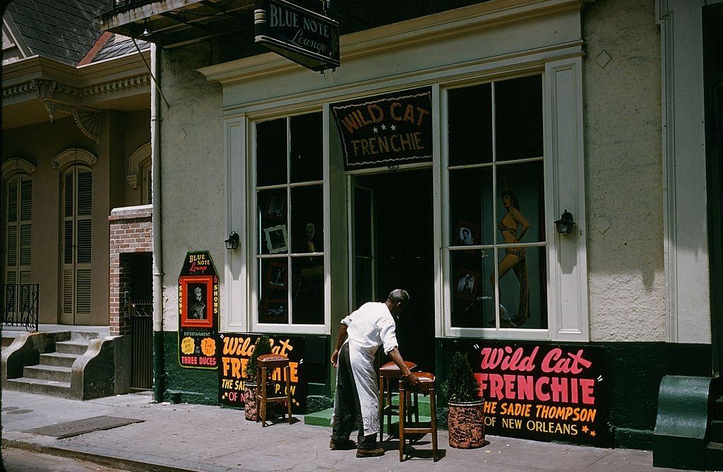 #76 A view down Bourbon street outside Wild Cat Frenchie Bar in New Orleans, 1957.