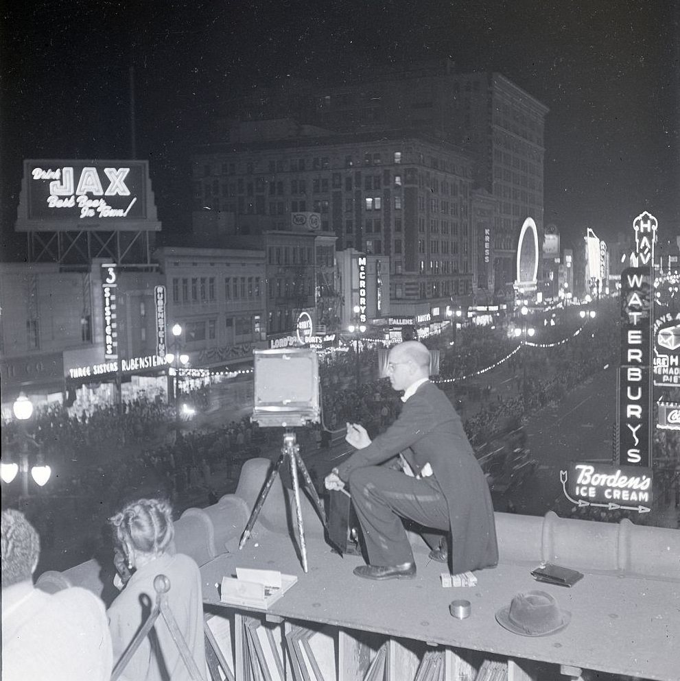 #35 A photographer snaps a shot of a crowded street during a Mardi Gras celebration, New Orleans, Louisiana, 1950.