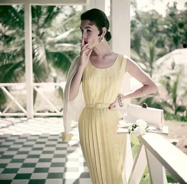 #13 Dovima wearing a pleated tube dress in Mimosa silk shantung, belted at the waist.