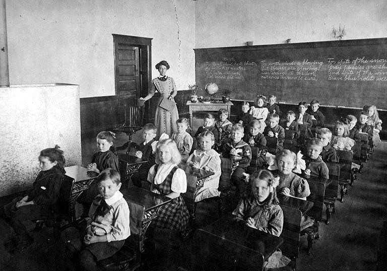 #64 Interior of classroom showing school children seated at desks, 1890