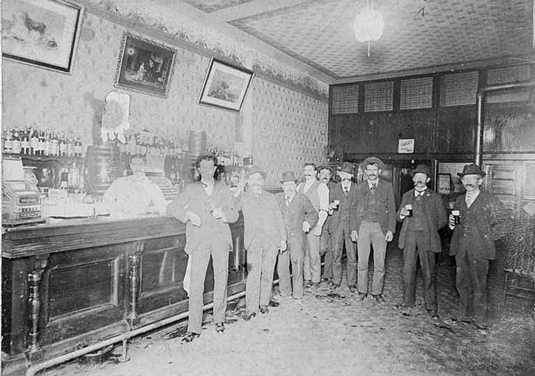 #163 Saloon interior showing men standing at the bar, Occidental Ave. and Washington St., 1895