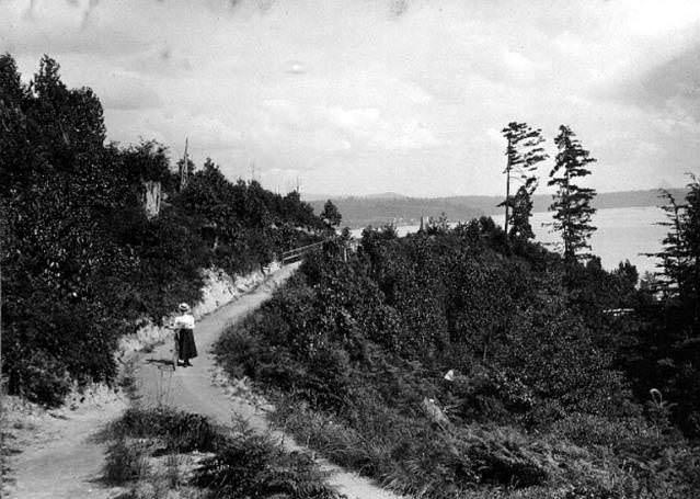 #56 Woman with bicycle on the Lake Washington bicycle path, 1899