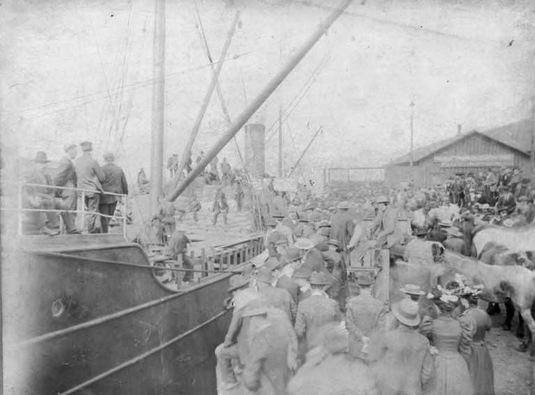 #4 Crowd of people and horses waiting at a wharf beside a docked ship, Seattle, 1889
