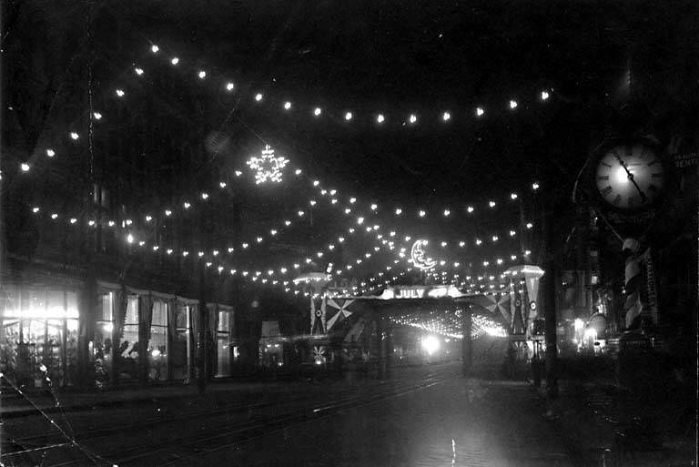 #3 1st Ave. decorated at night, 1899