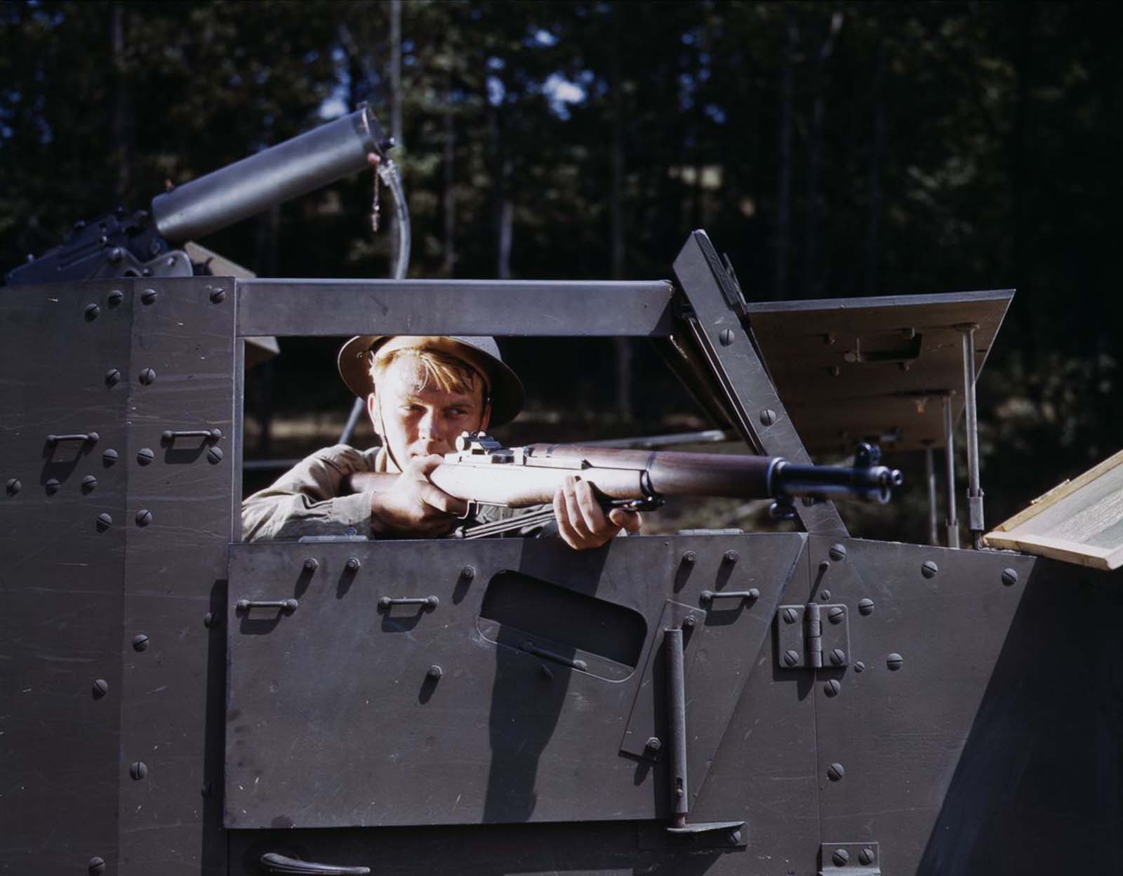 #8 An infantryman aims an M1 Garand from inside a half-track.