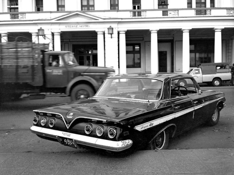 #17 Rangoon. 1961 Chevrolet Impala hardtop with right-hand drive, parked in front of the Strand Hotel, Burma, 1986