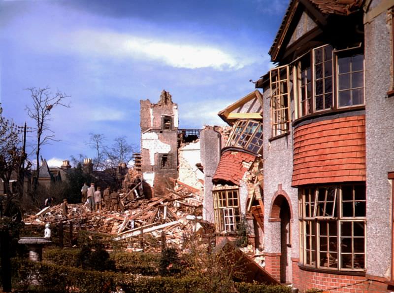 #16 Workers clear debris from the lot where a home once stood, London, 1940