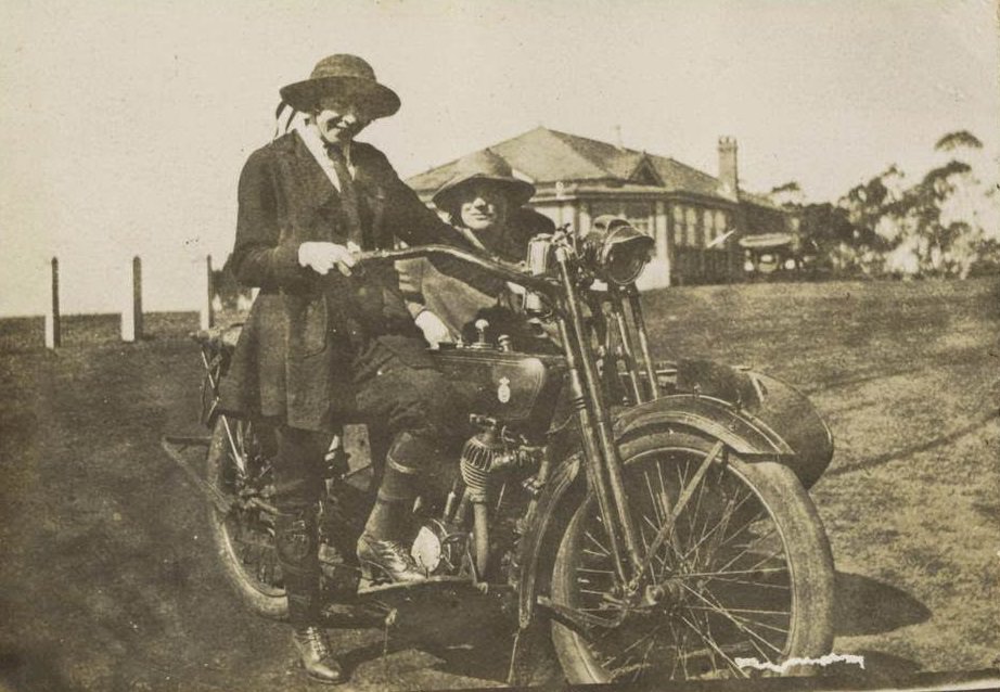 #23 Two women posing with a motorbike and sidecar, 1922.