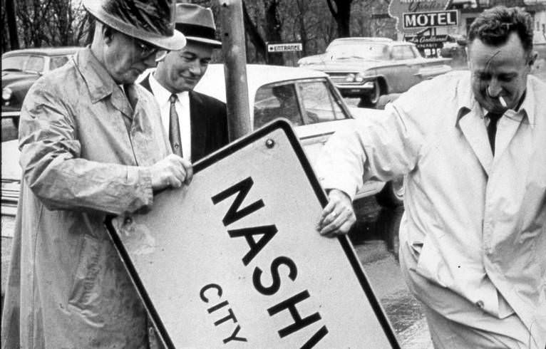 #110 Mayor Beverly Briley and others removing city limit sign, 1962