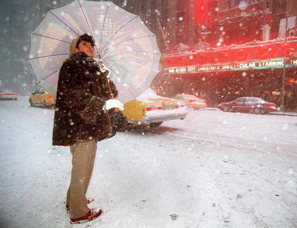#45 A woman looks skyward as she waits to cross the street outside Radio City Music Hall during the heavy snowfall 07 January in New York.