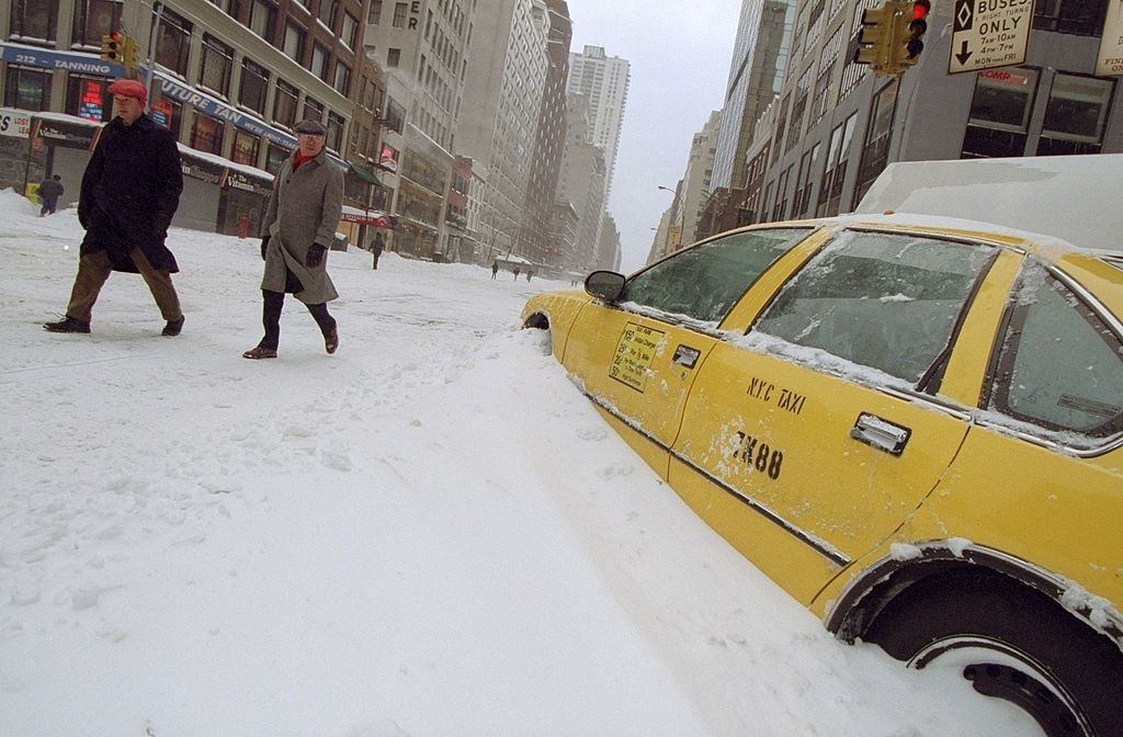 #60 Idle taxi cab sits buried in snow on 57th St. the day after a blizzard, 1996