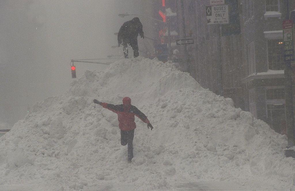 #63 Children climb up 30-foot piles of snow along the streets and sidewalks of Manhattan after a blizzard.