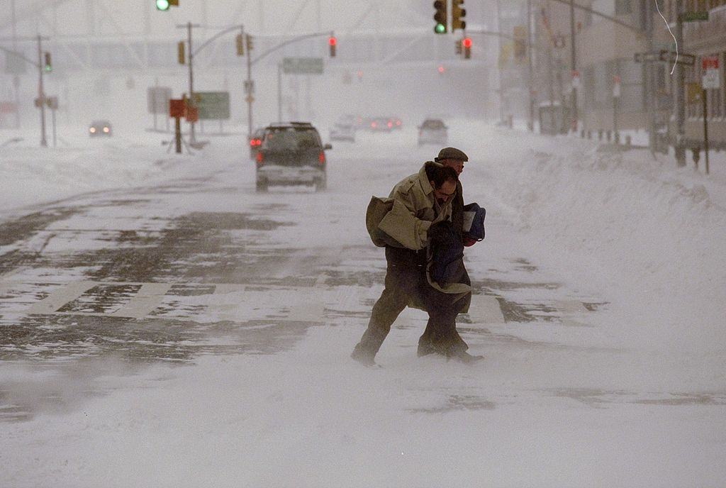#65 Pedestrians struggle to cross the street during a blizzard.