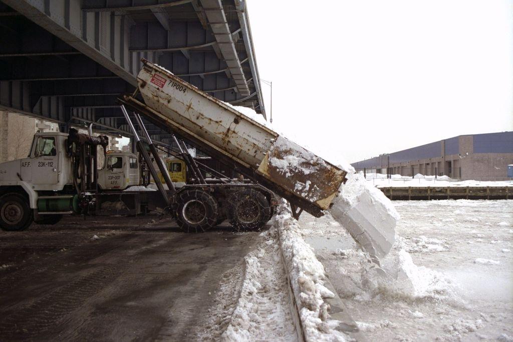 #84 Trucks dump the snow from city streets into the East River at Dike and South Streets after a blizzard.