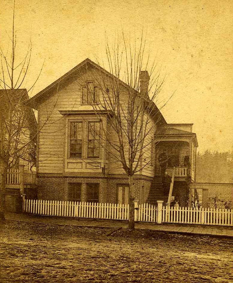 #22 Waughop House and residents on Main St. (now Capital Boulevard) between 5th & 6th (now Legion), Olympia, 1877