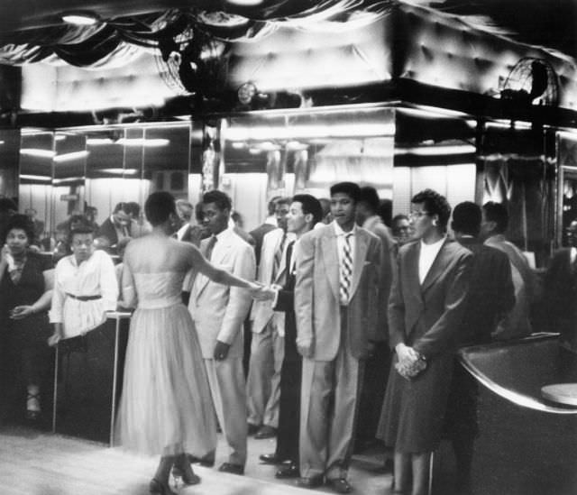 #16 Young people waiting to enter the dance hall, 1956.