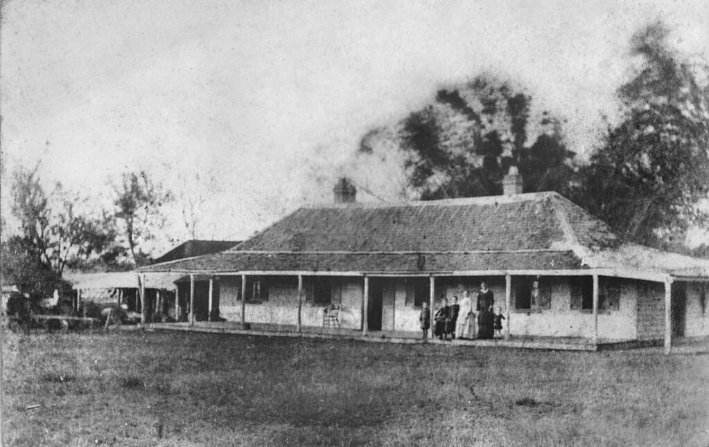 #62 Mrs White, with three children and members of domestic staff, on the verandah of Old Beaudesert Homestead