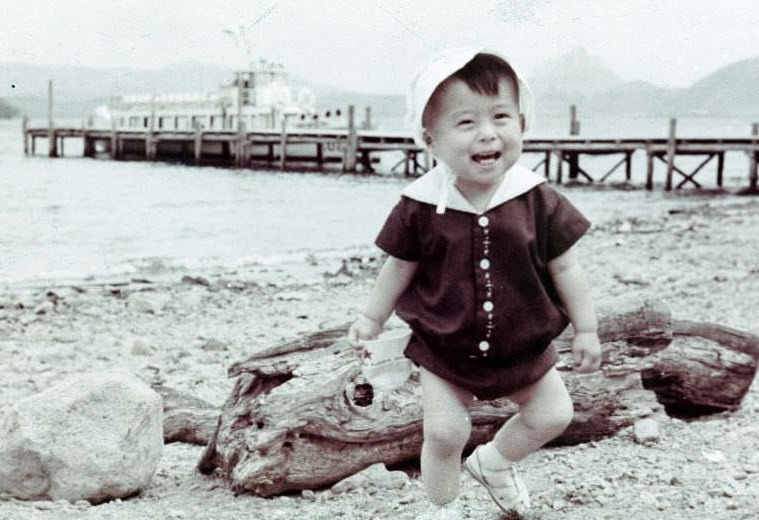 #129 Child running along a shore near a pier