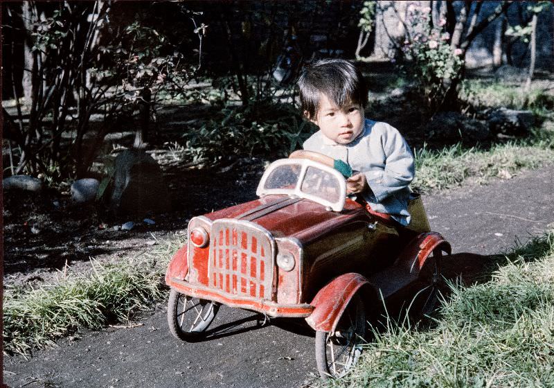 #130 Boy driving a metal toy car