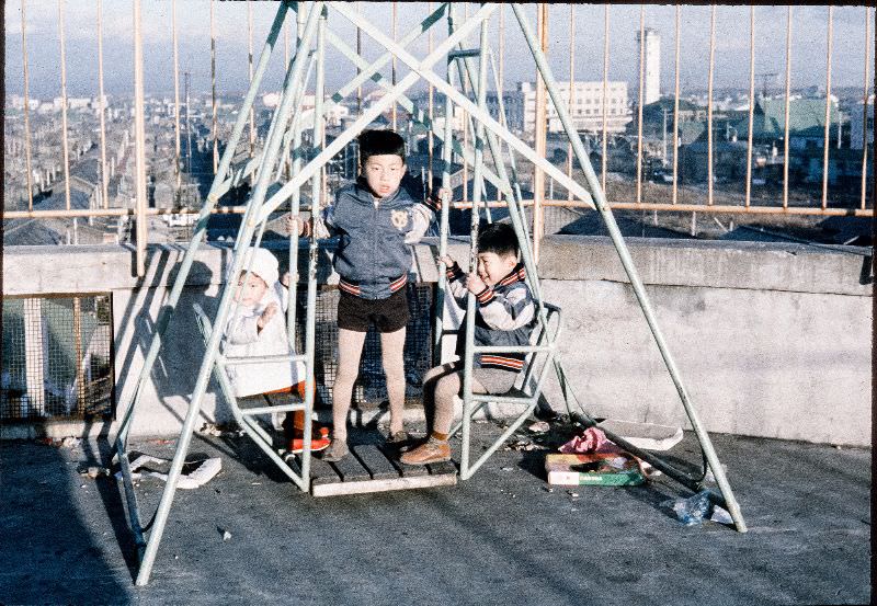 #136 Kids wearing Yomiuri Giants jackets on a swing