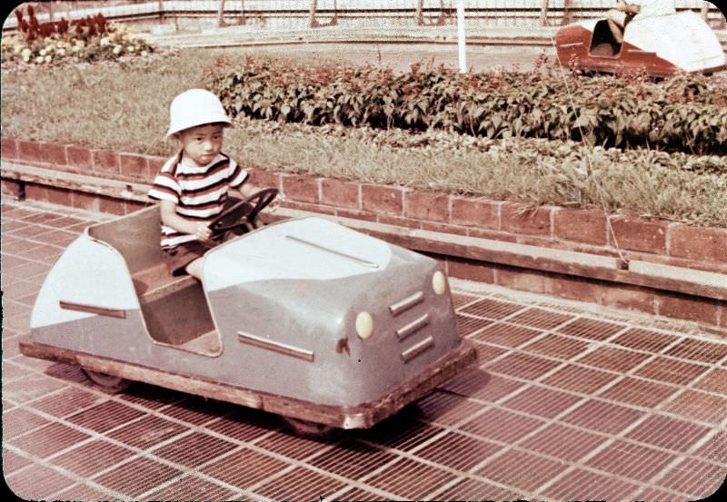 #137 Little boy in a hat driving a metal toy car