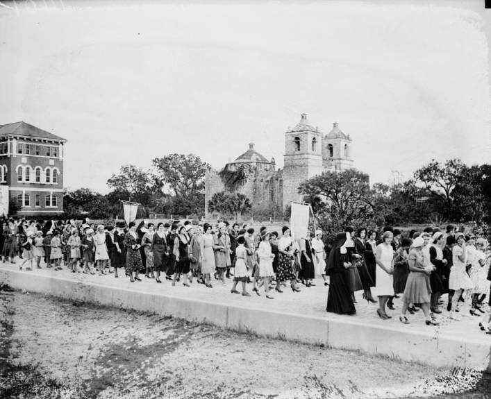 #126 Feast of Christ the King procession from St. John’s Seminary (background, left) to St. Peter’s and St. John’s Orphanage. Mission Concepción in background, 1930