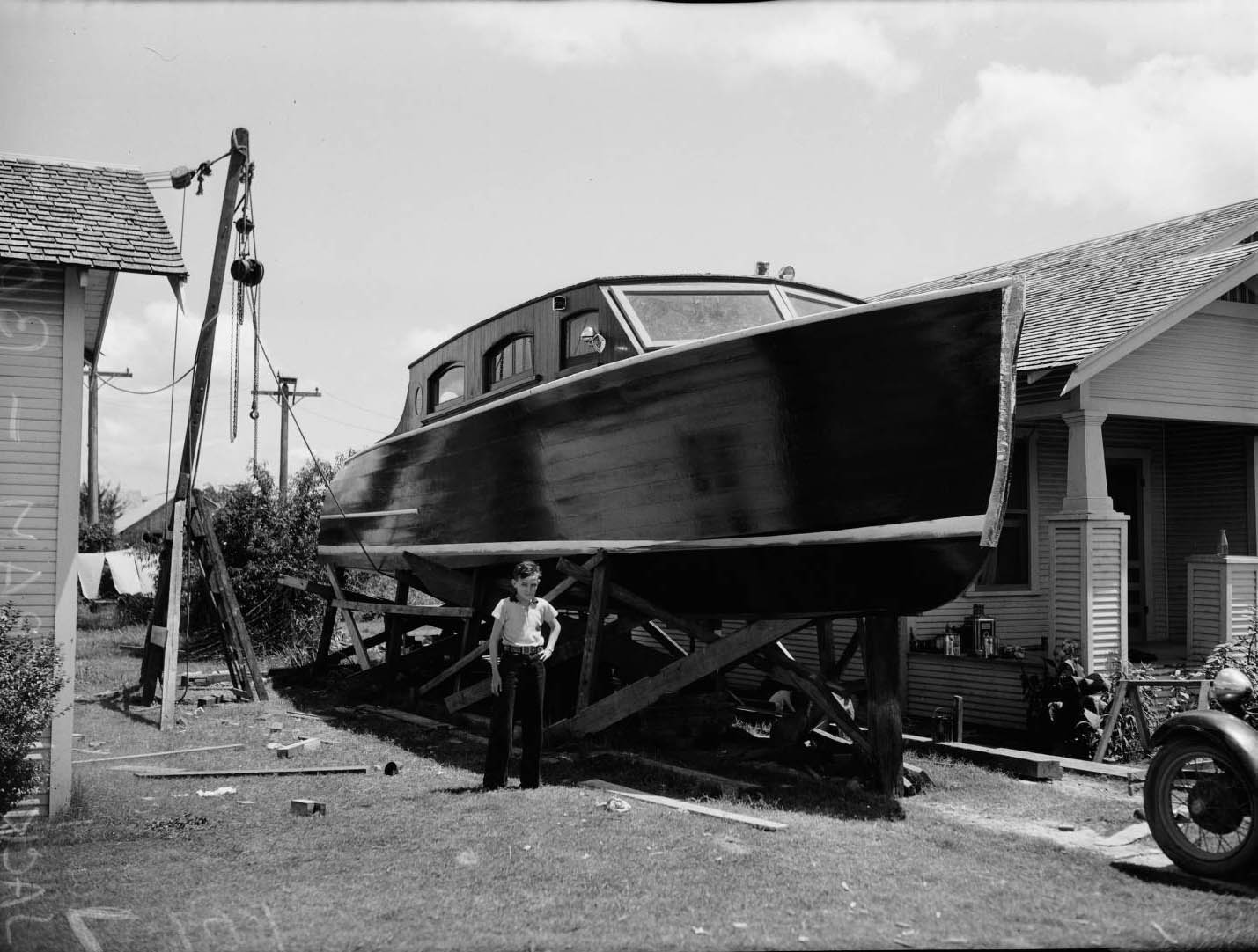 #168 Portrait of Wallace Ingram standing in front of a 43-foot pleasure boat his father, Jack Wallace, 1936