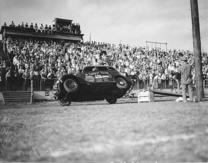 #61 Lucky Teter, a daredevil automobile stunt driver, attempting to turn over a 1935 Plymouth 4 drive car at Hell Drivers exhibition at Eagle Field.