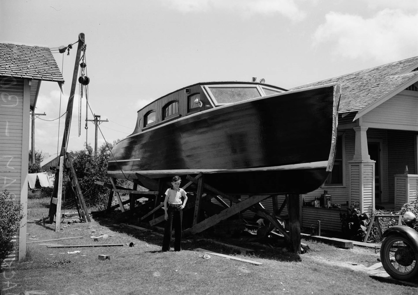 #78 Portrait of Wallace Ingram standing in front of a 43-foot pleasure boat his father, Jack Wallace, had recently completed building, 1936