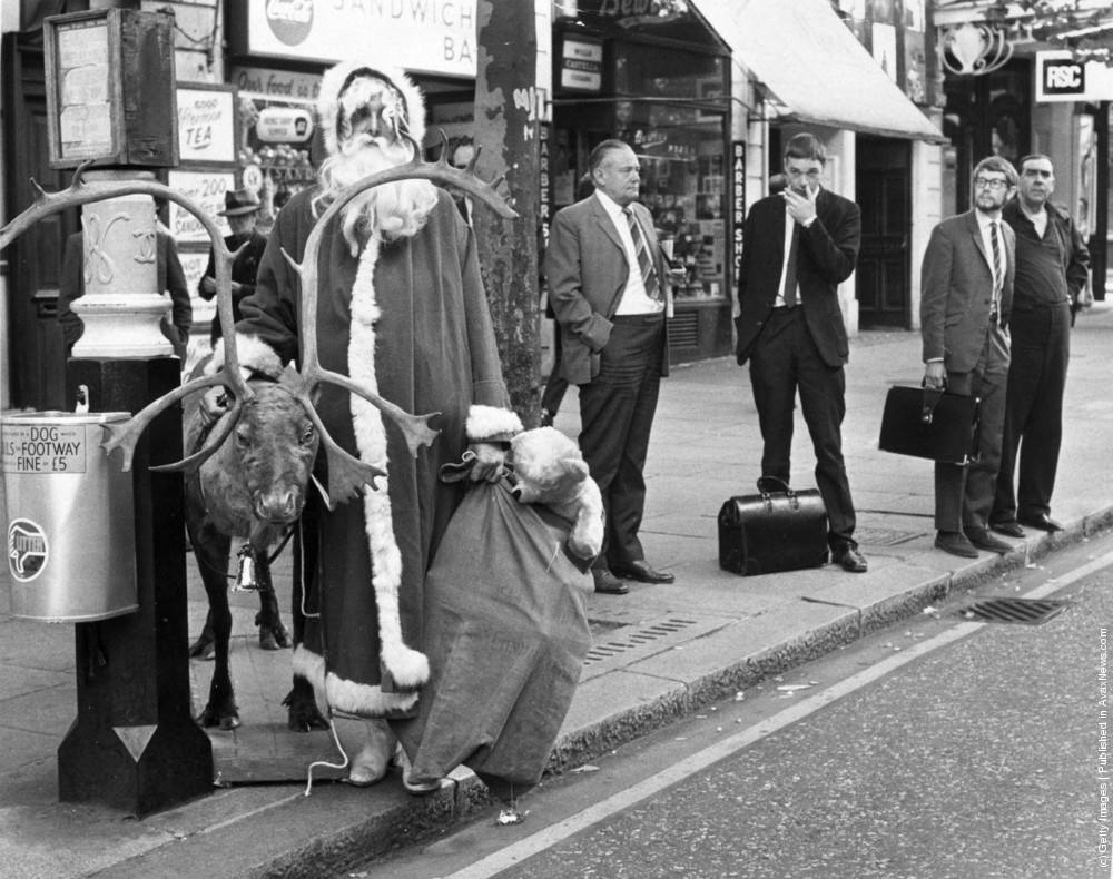 #27 Father Christmas waiting for a bus in the London West End with his reindeer and a sack of presents, 12th August 1970