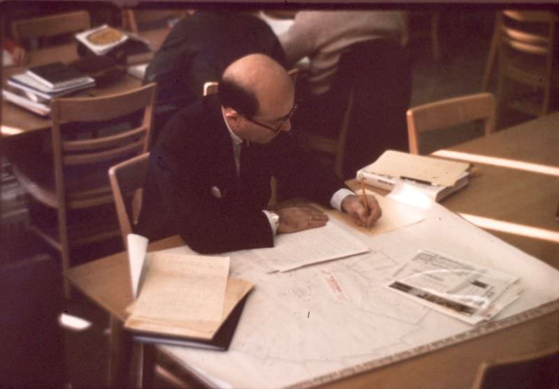 #20 Library Director, William Joyce, examining floor plans for the planned LRC building (opened 1971), December 1969