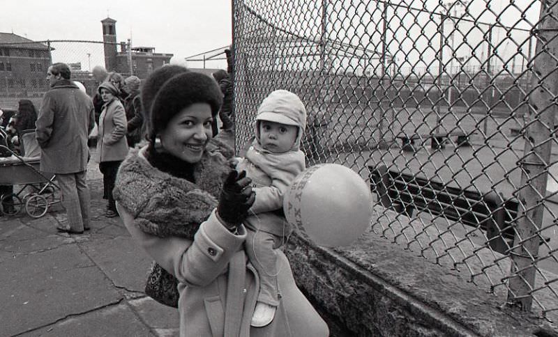 #7 Woman holding a child at North End Christmas Party and Parade