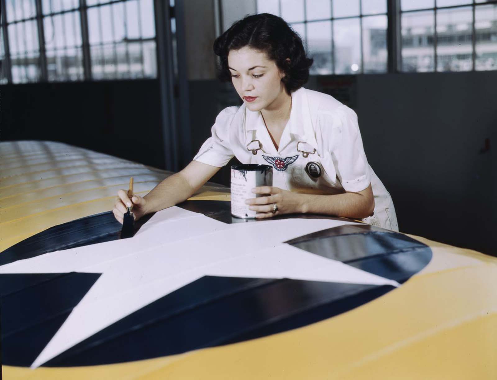#20 Irma Lee McElroy, a former office worker, paints an insignia on an airplane wing.