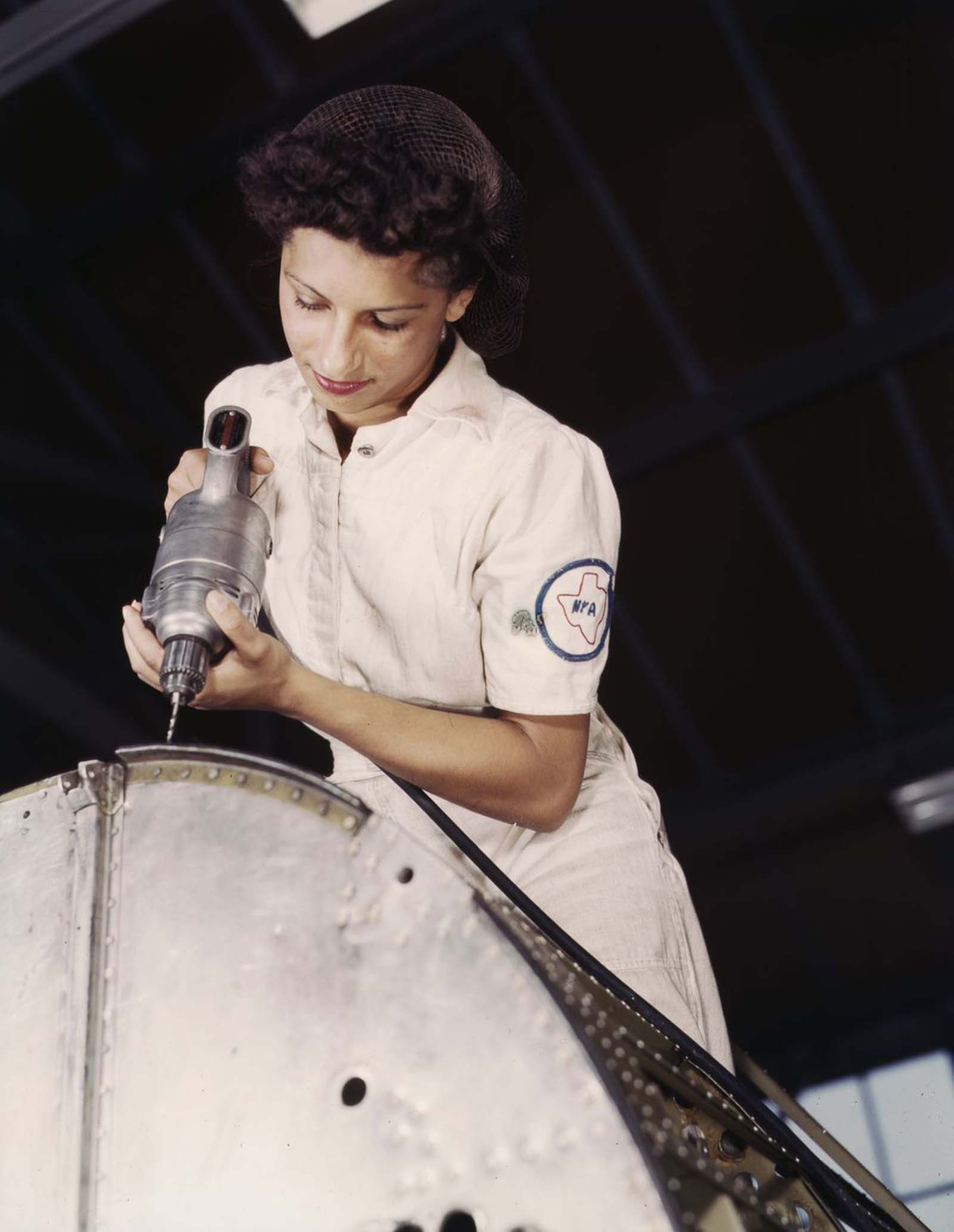 #23 Oyida Peaks rivets as part of her NYA training to become a mechanic in the Assembly and Repair Department.