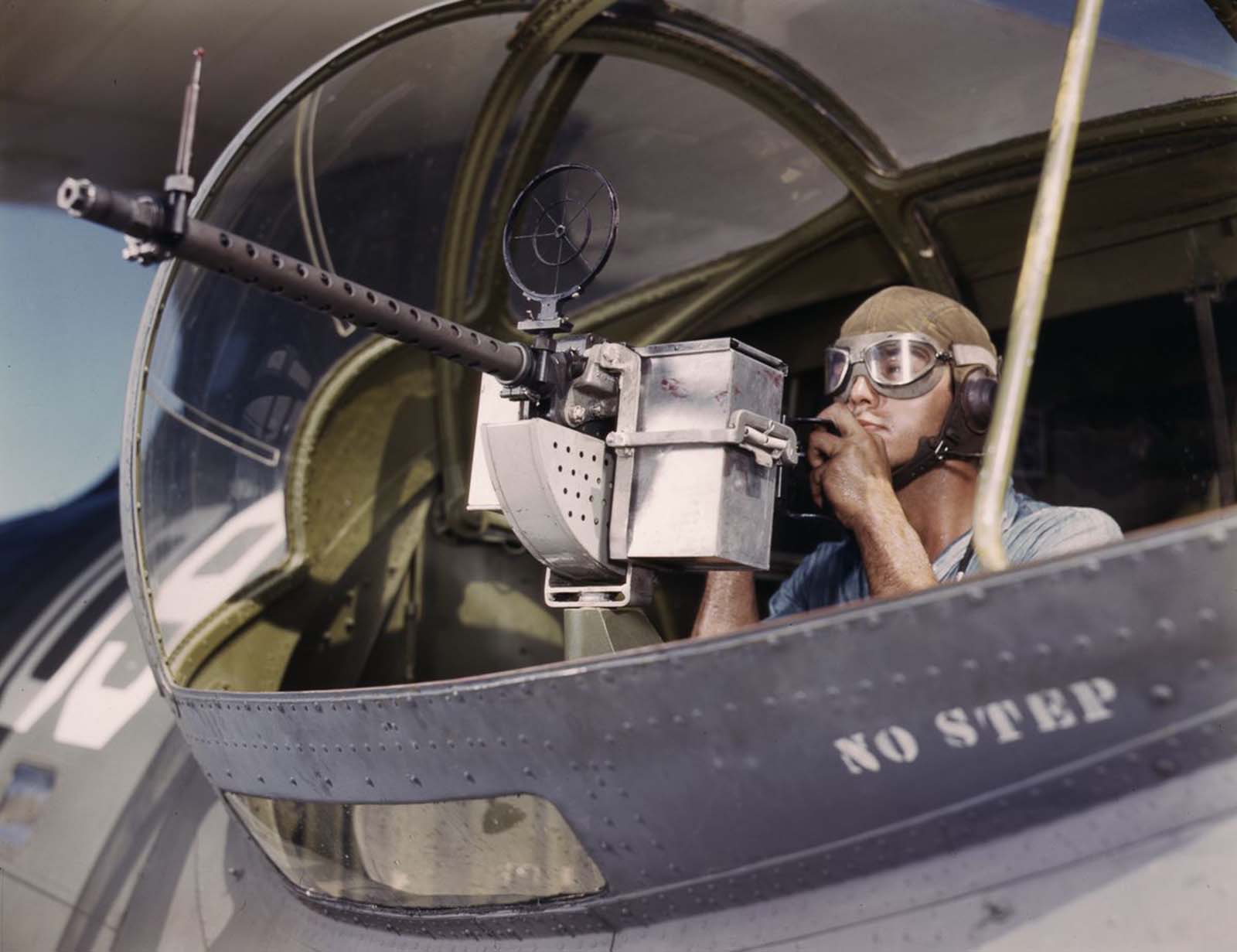 #9 Jesse Rhodes Waller, A.O.M., third class, tries out a .30-caliber machine gun he has just installed on a Navy plane.
