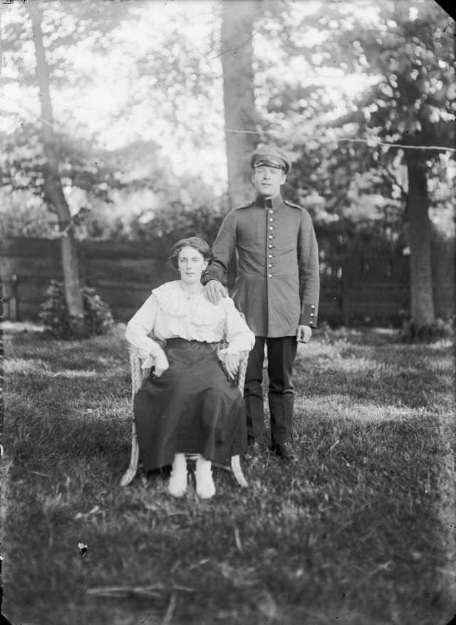 #29 Woman in a chair with a man in the uniform of the German internees from the internment camp on the Breelaan, 1916