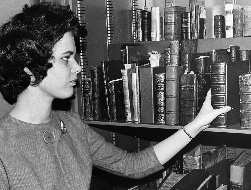 #163 Janice Maniscalco, of the Boston Public Library’s rare books department, reaches for a book in the library’s rare book vault on Oct. 16, 1962.