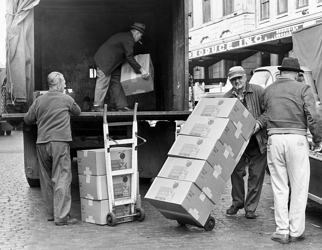 #168 Men load boxes into a truck at the Faneuil Hall market on Sept. 25, 1962.
