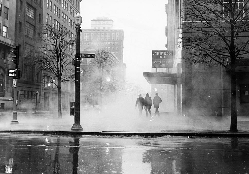 #177 Ground fog swells up around three pedestrians walking past the entrance to John Hancock Hall and the Dorothy Quincy Suite at Stuart and Berkeley Streets in Boston at 6:30 a.m. on March 5, 1967.