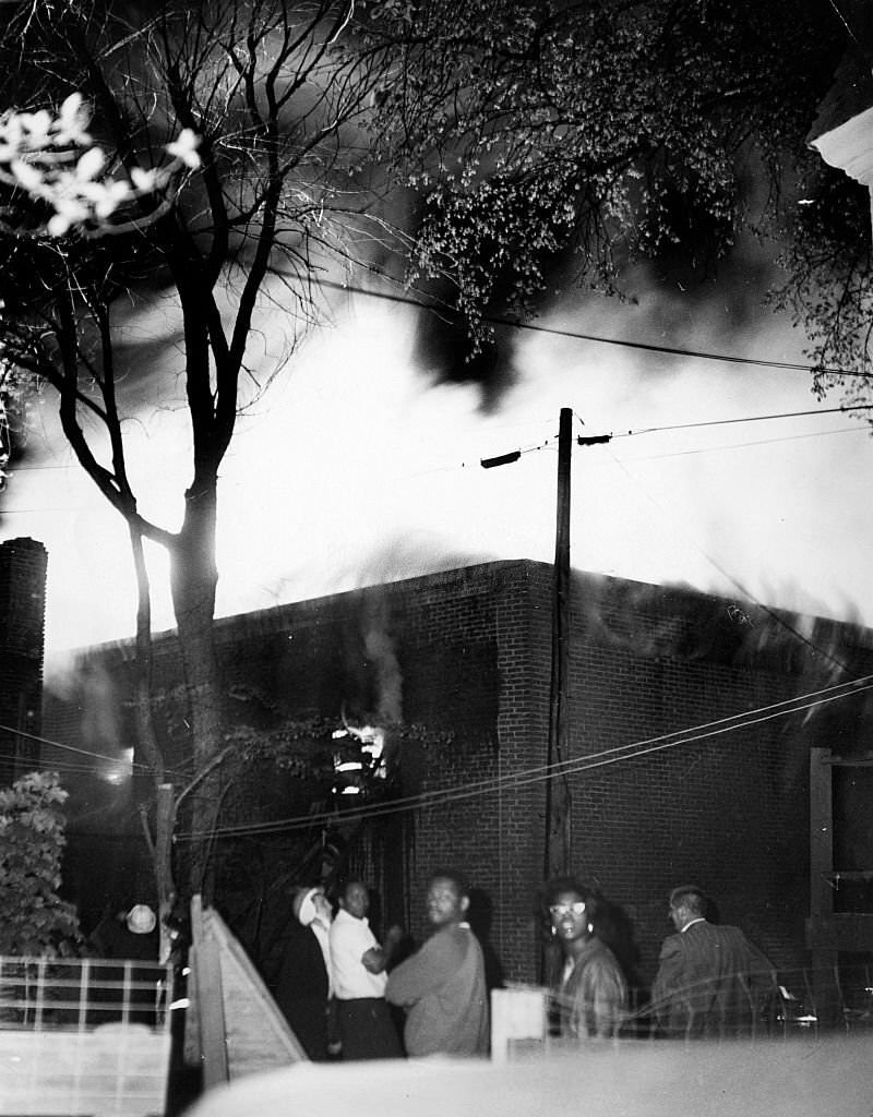 #191 People watch as a three-alarm fire burns in a paint store on Blue Hill Avenue in the Roxbury neighborhood in Boston on June 3, 1967.
