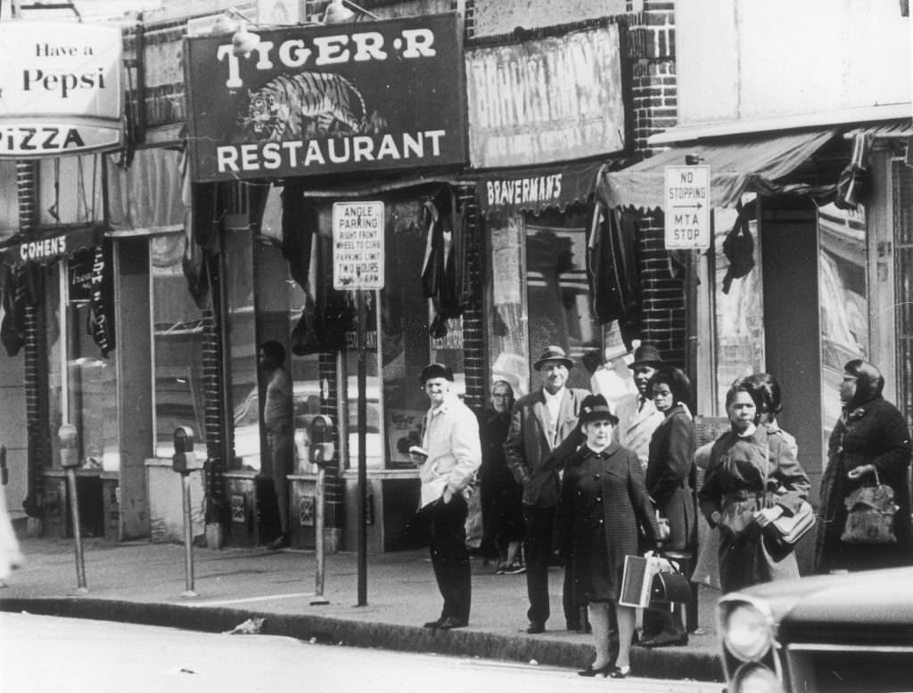 #245 People wait for the bus at an MTA stop next to the Tiger Restaurant on Blue Hill Avenue in Boston on May 4, 1969.