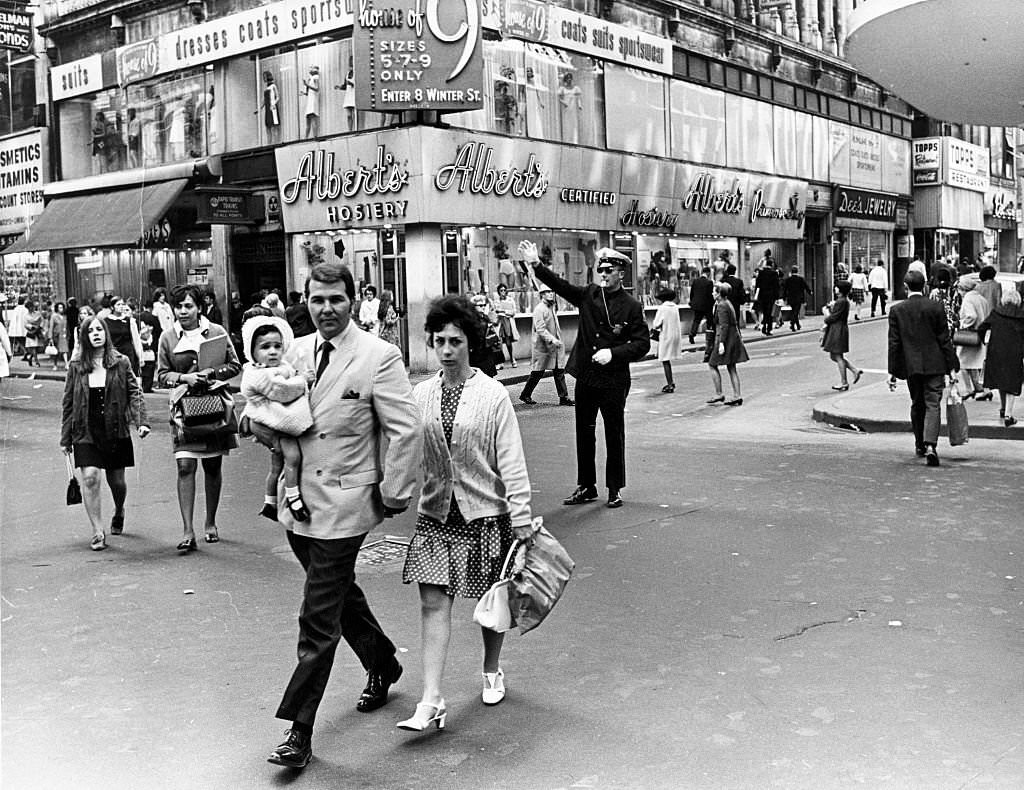 #287 A police officer tries to direct foot traffic at the intersection of Washington Street and Summer Street in Boston on May 13, 1969.