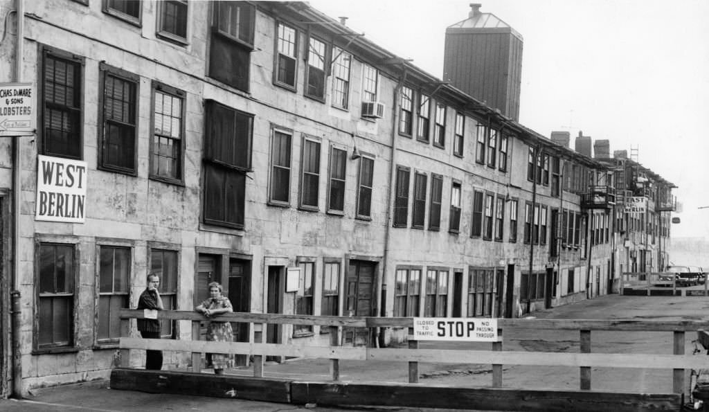#37 J.W.S. Cox, left, and Ms. Helen Sherman, right, lean on a new fence put up at the T Wharf in Boston, Sept. 5, 1961.
