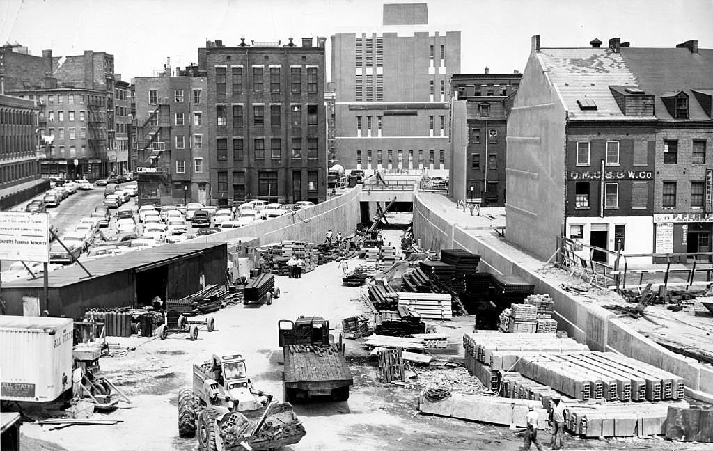 #42 Men, machines, and material clutter the ramp leading to the new under-harbor crossing, the Callahan Tunnel, seen from Cross Street in Boston on July 13, 1961.